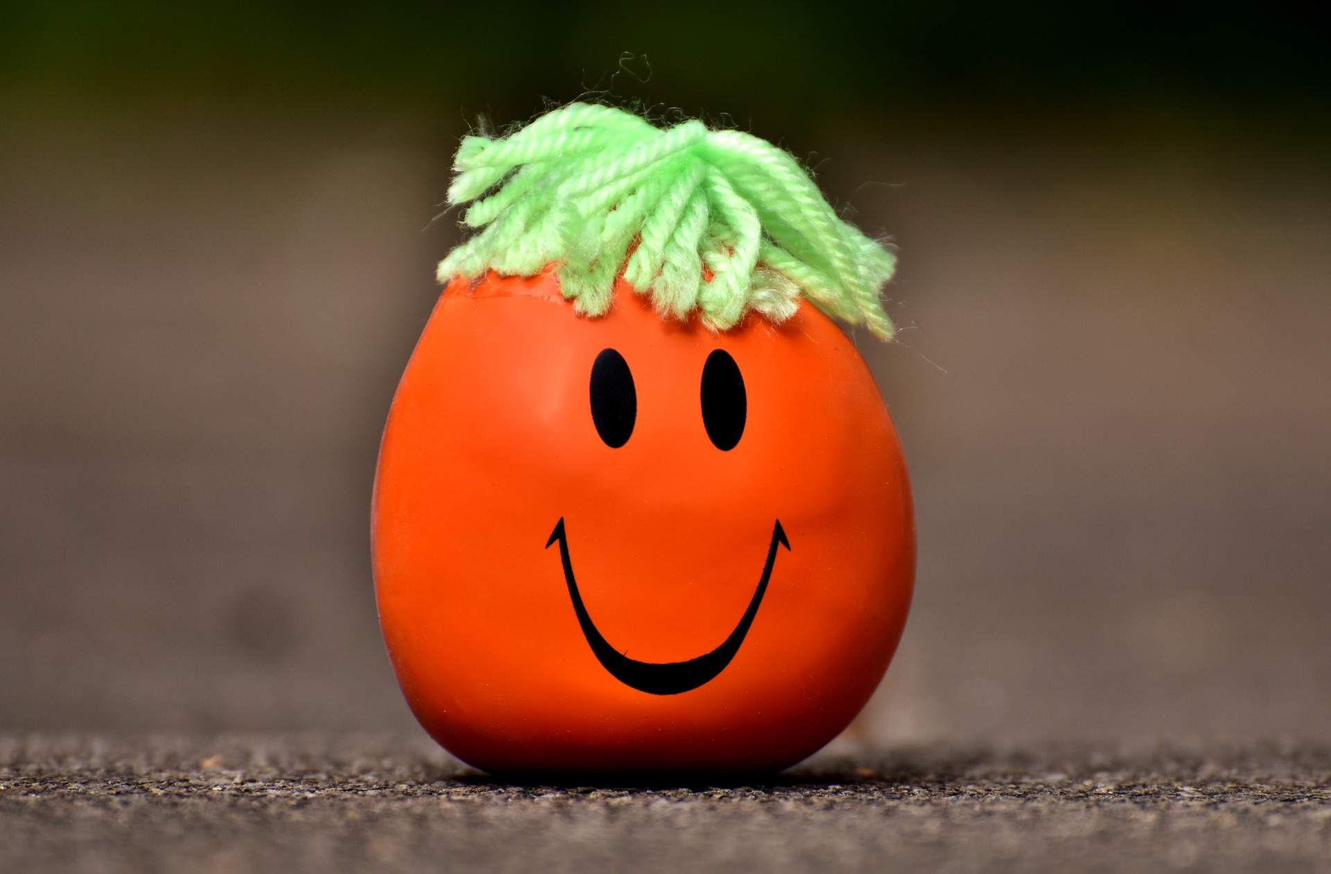 Balle anti-stress smiley orange avec des cheveux en laine
